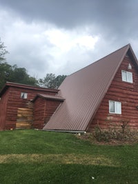 a house with a red roof and a grassy yard