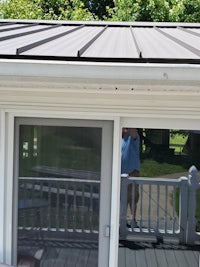 a metal roof on a house with a sliding glass door