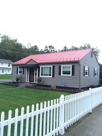 a house with a red roof and a white picket fence