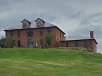 a brick house on top of a grassy hill