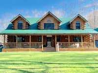 a large log home with a green roof