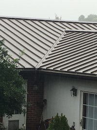 a house with a metal roof in the rain